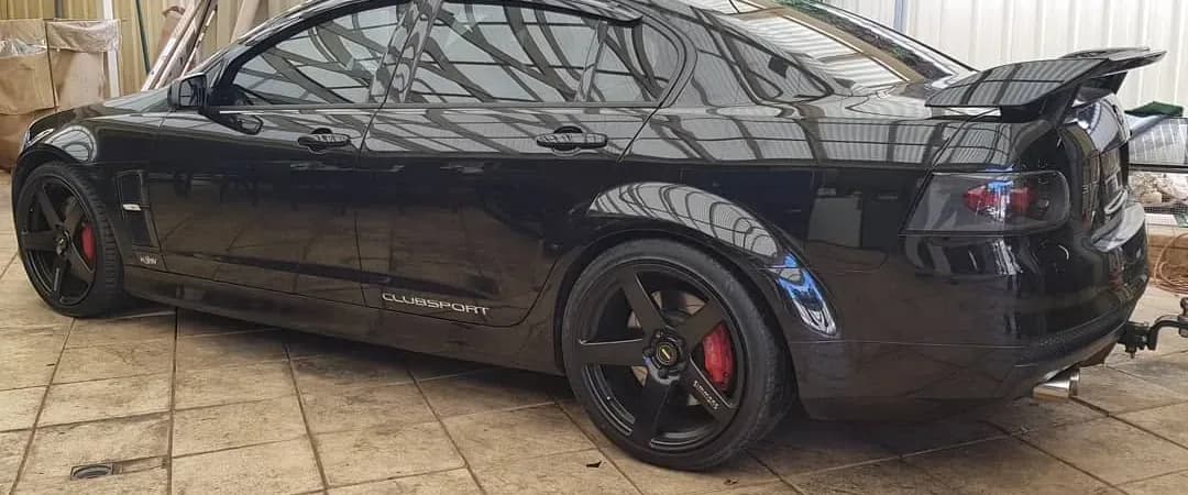 A black Holden Commodore SS with dark tinted windows in the Pro Tint Adelaide workshop